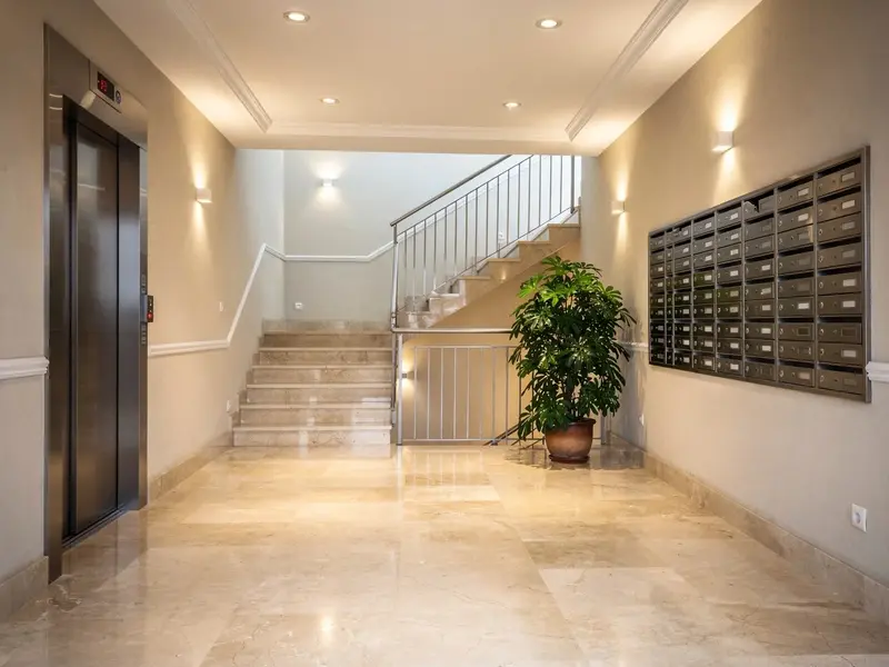 Portal de comunidad de vecinos con suelo de mármol reluciente