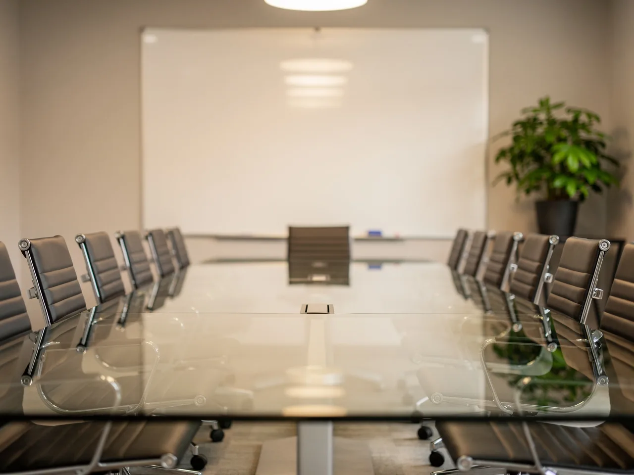Sala de reuniones limpia con mesa de cristal y pizarra