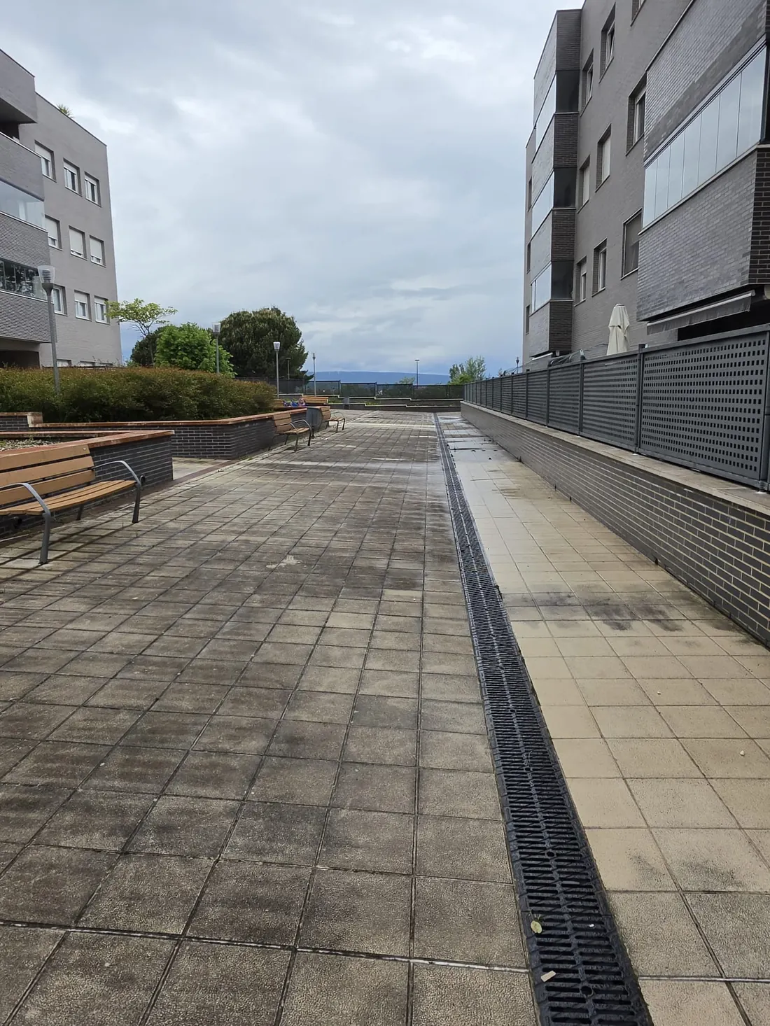 Mismas baldosas tras la hidrolimpieza profesional en una terraza comunitaria de Vitoria